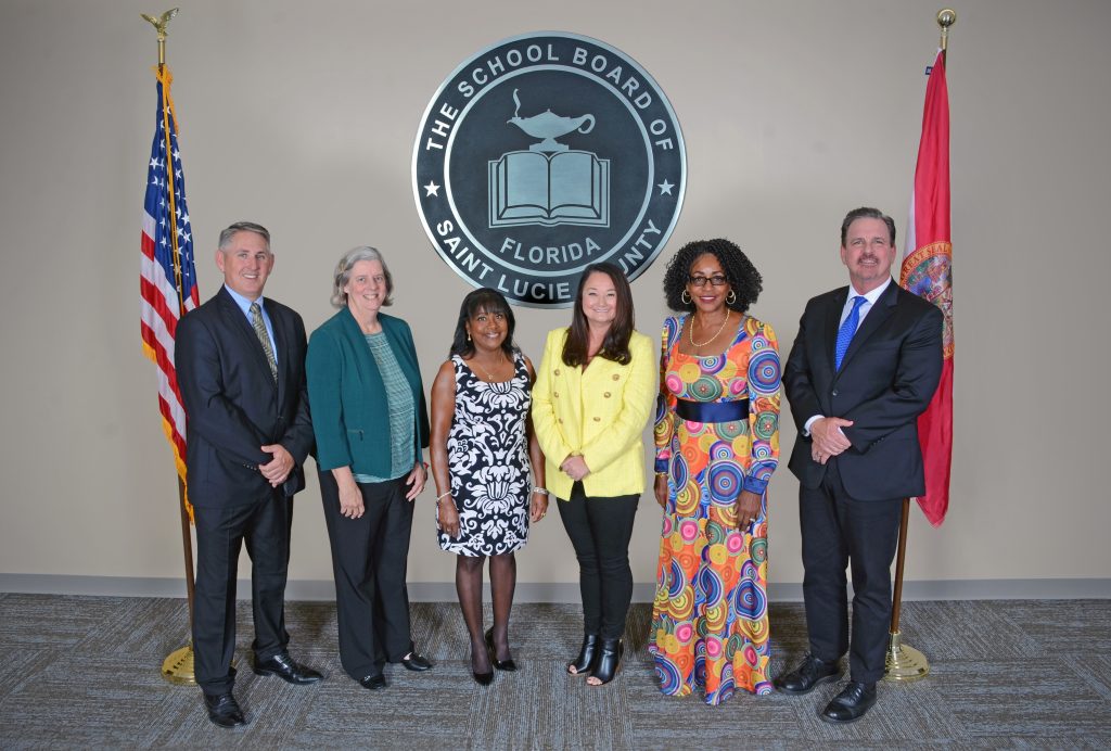 BOARD PHOTO Group of six school board members posing in front of St. Lucie County logo