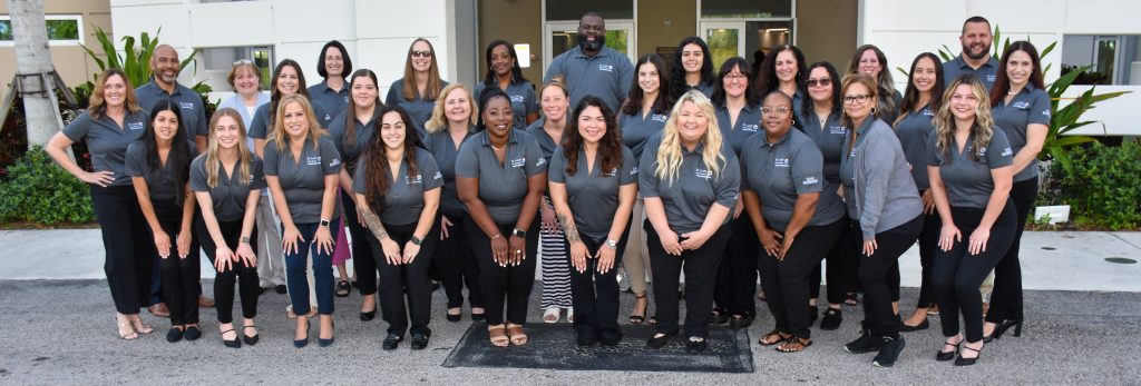 HR Group Group of smiling team members in matching uniforms outside a building